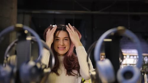 Smiling Woman Enjoying Music From New Headphones in Electronics Store