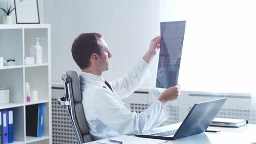 Professional Medical Doctor Working in Hospital Office Using Computer Technology