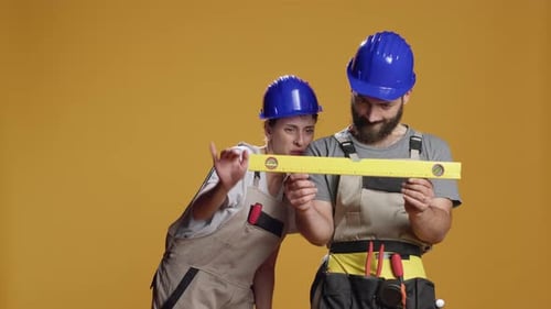 Construction Workers Examine Spirit Level Together in Studio
