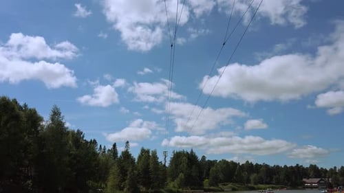 Man or Woman flys through shot on zip line on Sunny day