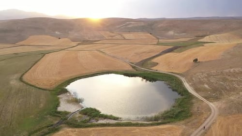Vue aérienne des collines du lac et des terres agricoles au coucher du soleil