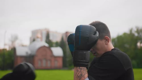 Boxing Session Outdoors Male Boxer Warms Up Outside Boxer Practicing Defensive Moves in Park