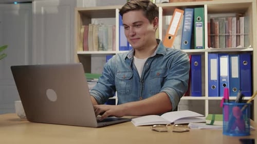 Nicelooking Ambitious Young Man Enjoying Working in Modern Office Keyboarding on Laptop Computer
