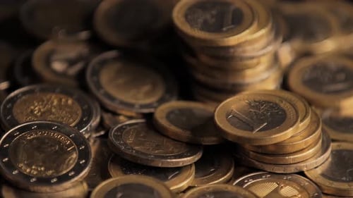 Rotating pan shot of bunch of euro coins. Closeup view.