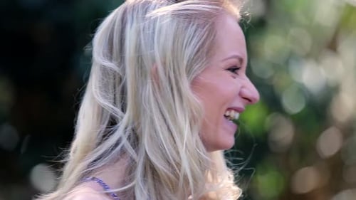 A close-up shot of a blonde woman laughing and being happy