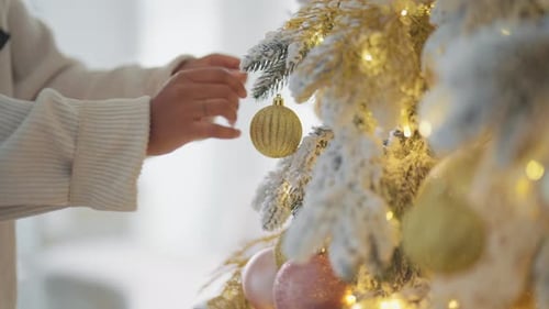 Decorating Christmas Tree with Gold Ornaments at Home