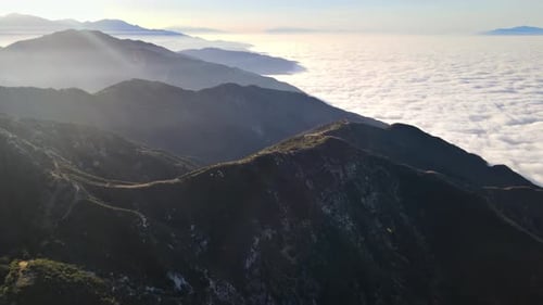 Luftbild von Bergen über niedrigen Wolken in der Morgendämmerung