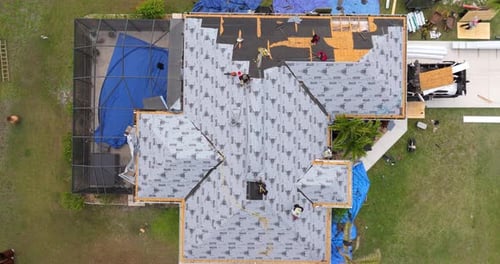 Aerial view of roofers working on residential roof