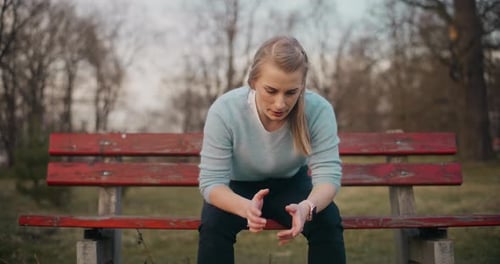 Woman Waiting on Park Bench Checking Time