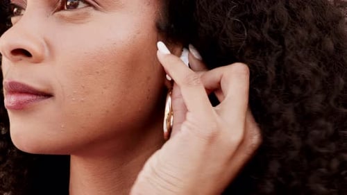 Woman Putting Wireless Earbud in Ear, Close-Up