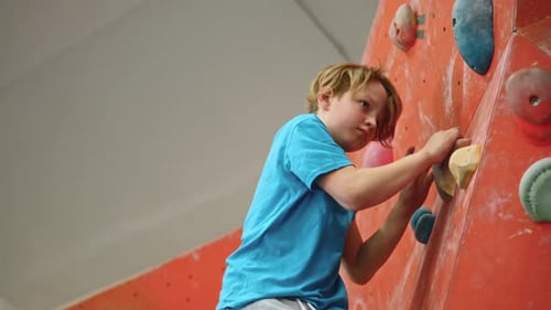 Young Boy Climbing Rock Wall Indoors