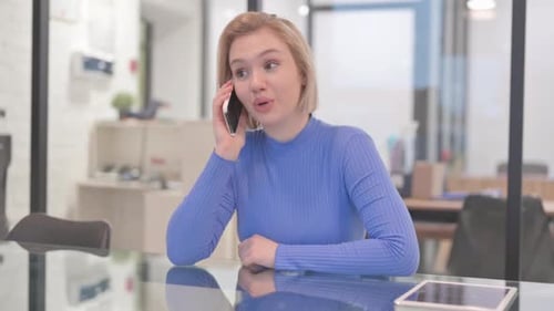 Young Woman Talking on phone in Office