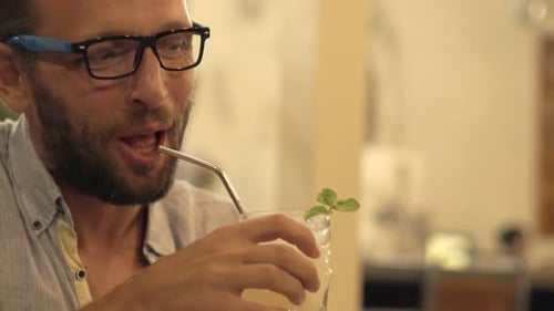 Happy Friends Talking and Raising Toast with Cocktails Sitting in Cafe Adult