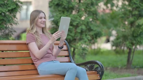 Young Woman Doing Video Chat on Tablet Outdoor
