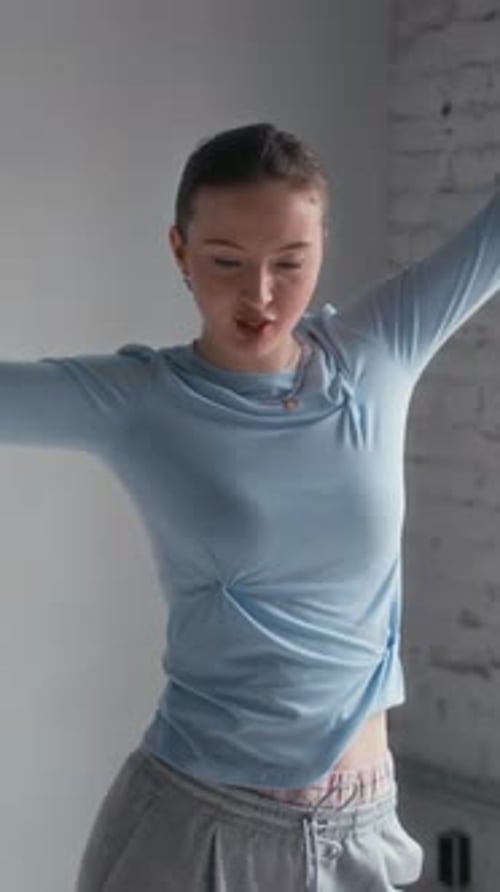 Vertical of Girl in Urbanwear Dancing on Camera in Studio