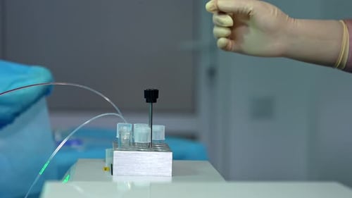 Liquides remplissant les tubes à essai. La main du médecin dans des gants attend le remplissage des réservoirs. Gros plan.