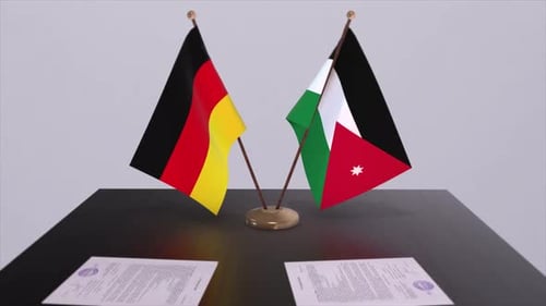 Germany and Jordan Flags on Table with Documents