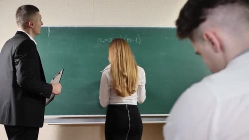 Une jeune étudiante passe un examen près du tableau