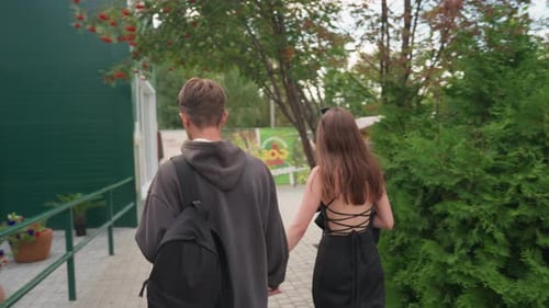 Young Couple Holding Hands Strolling Along Urban Path