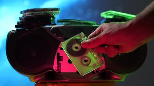 Hand Inserts Cassette Into Boombox