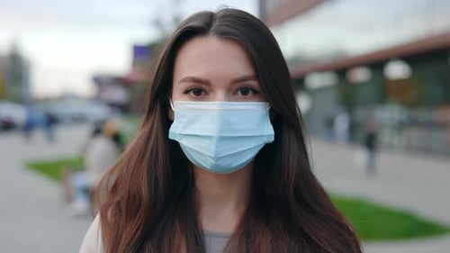 Woman Wearing Surgical Mask on City Street