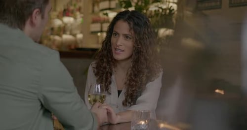 Young Adult Couple on a Date in Bar Restaurant Holding hands