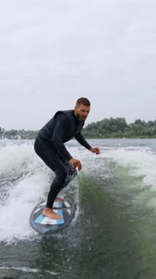 A Surfer Perfects His Skills on a Calm Waterway Riding the Waves with Grace and Focus During a Chill