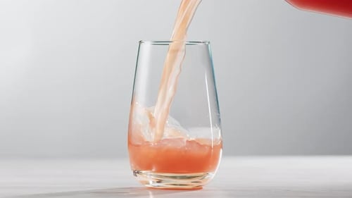 Pouring Red Juice Into Glass in Mid Shot