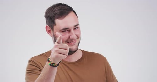 4k video footage of a young man pointing at the camera against a grey background