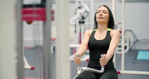 A Woman Performs Seated Cable Rows in the Gym