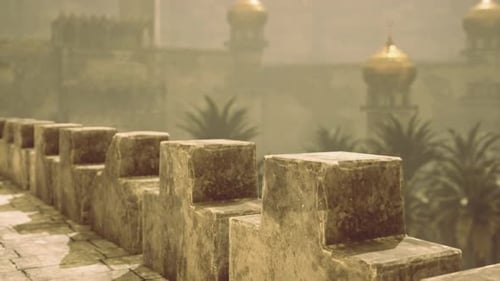 Ancient Stone Walls with Golden Domes Under a Hazy Sky at Dusk
