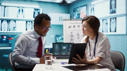 Doctor Showing Tablet to Patient in Clinic Office