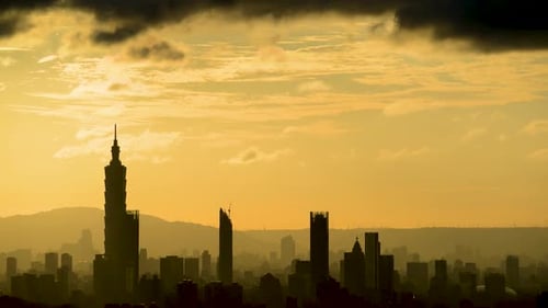 A combined view of the moving sun and city tower landmarks at sunset.