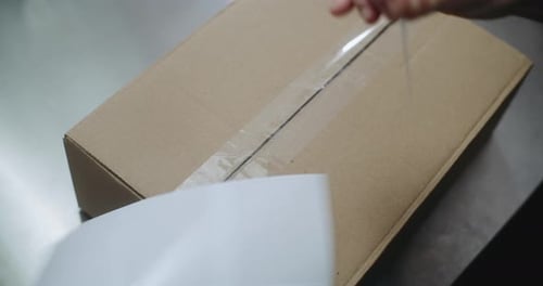 Close Up of Postal Worker Putting Sticker on Package Scanning Code Preparing for Shipping