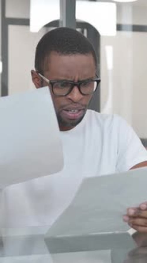 Man looks at documents with frustrated expression