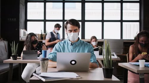 Portrait of Young Businesspeople with Face Masks Working Indoors in Office
