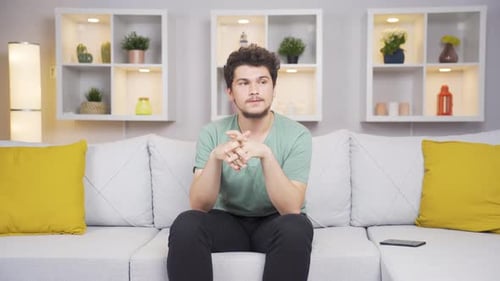 Young Adult Male Praying Indoors On Sofa