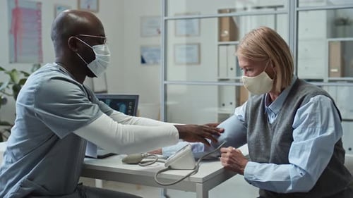 Doctor Checks Patient's Blood Pressure in Office