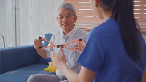Senior Man Exercising With Resistance Band At Home