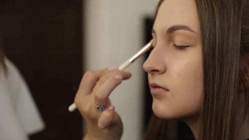 Makeup Artist Applying Eyeshadow on Woman's Eyelid