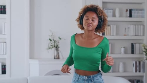 Woman Dancing to Music in Brightly Lit Room