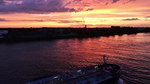 Ship Sailing on River at Sunset