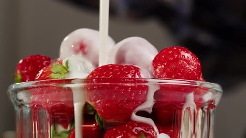 Cream Poured on Fresh Strawberries in Glass Bowl