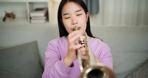 Young Adult Plays the Trumpet at Home