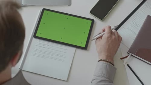 Man Doing Paperwork and Using Digital Tablet with Green Screen