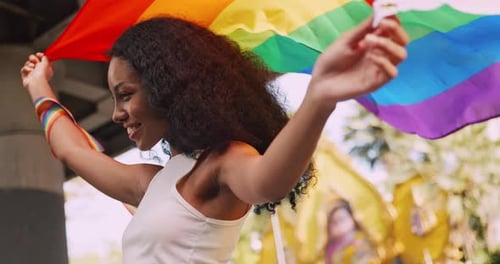Young Adult Holding Rainbow Pride Flag at Celebration