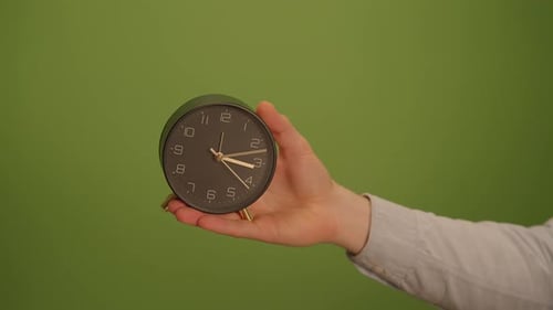 A Vintage Alarm Clock on a Green Background Offers Nostalgic Charm and Eyecatching Appeal