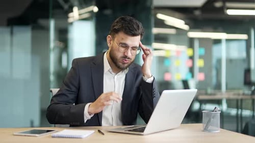 Man at Desk Feeling Stressed with Headache