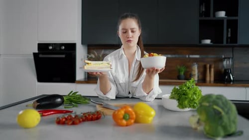 Mujer joven elige alimentos saludables a dieta Niña pensativa elige entre un sándwich y prepara verduras