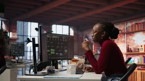 Programmierer isst Snacks am Schreibtisch und programmiert fortgeschrittenen KI-Algorithmus im Startup